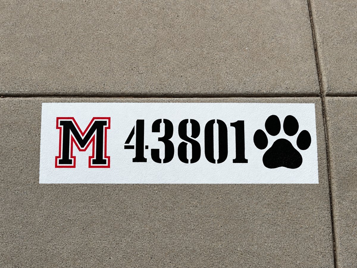 Freshly painted white curb block with black house numbers 43801, a red varsity M and a black paw print